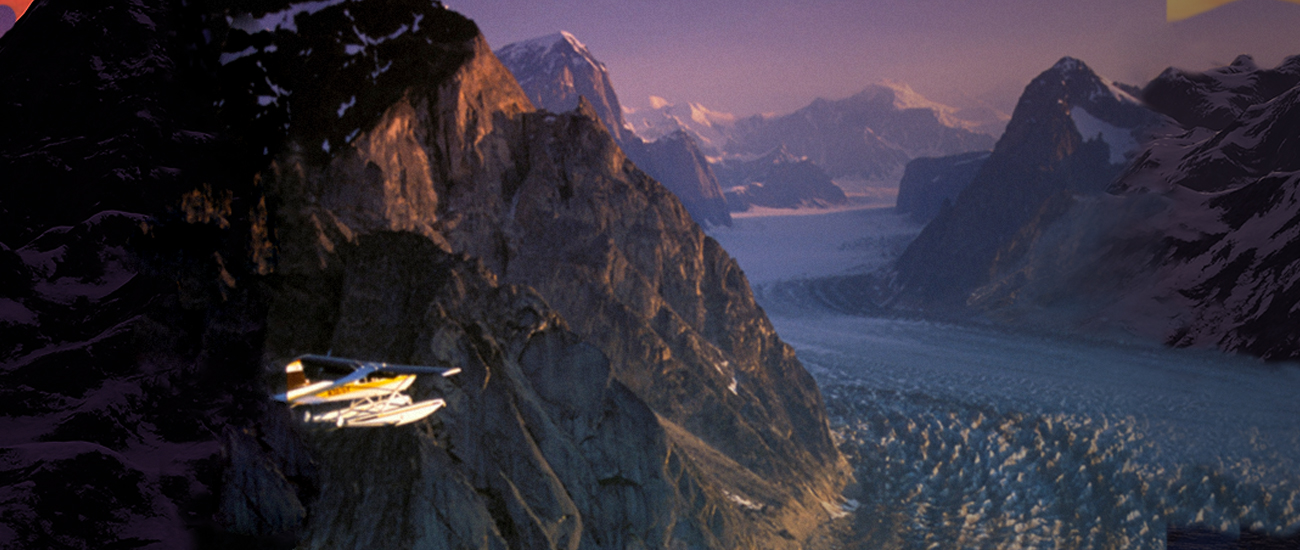 An aircraft flies over a stunning mountain